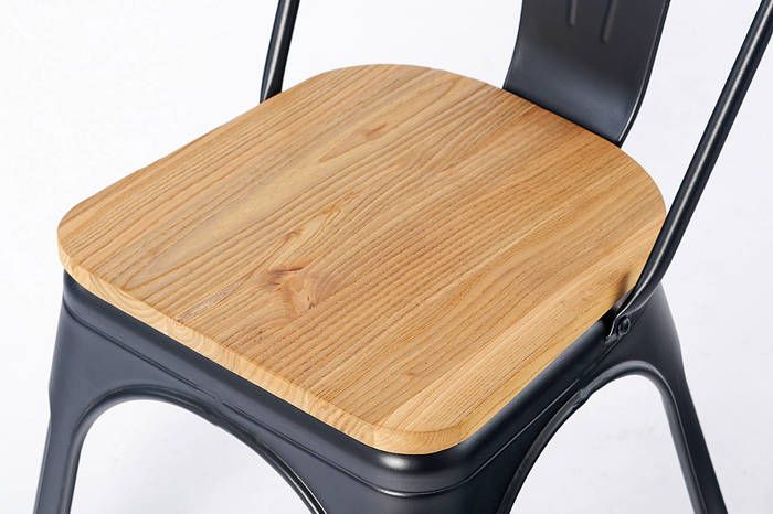 Die Sitzfläche aus hellem Holz erzeugt einen spannenden Kontrast zur dunklen Stuhlfarbe
