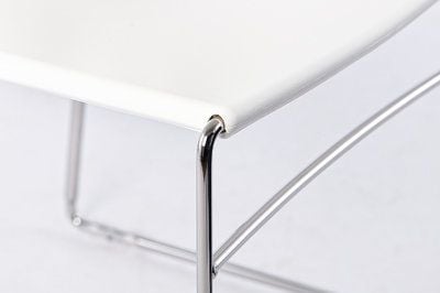 Die Sitzfläche wird von einem Stuhlgestell aus Stahlrohr gehalten