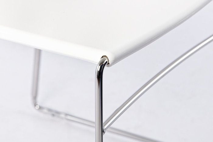 Die Sitzfläche wird von einem Stuhlgestell aus Stahlrohr gehalten