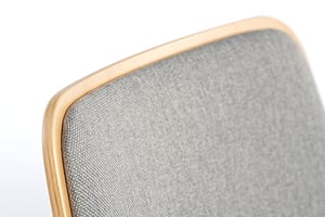 Die Polsterung der Rückenlehne passt sich der Form der Holzschale an