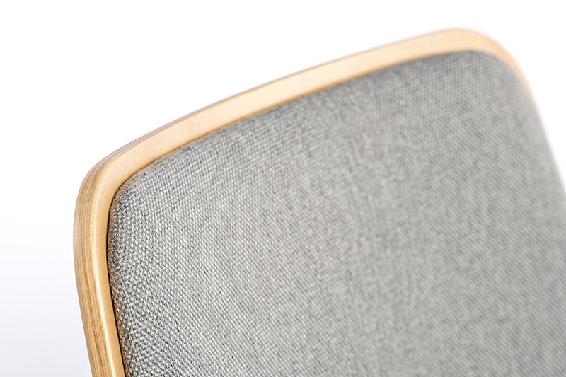 Die Polsterung der Rückenlehne passt sich der Form der Holzschale an